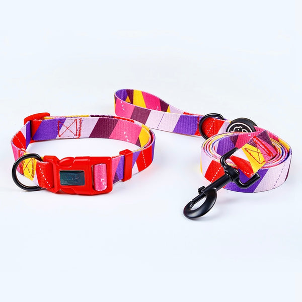 Bright geometrical dog collar and leash set, with different shades of purple and pinks being the primary colours of the set with some red, black metal D rings and 360 degree swivel snap hook and a red quick release buckle for safety. Name of set is Sunrise